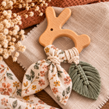 Anneau de dentition lapin en bois naturel avec tissu fleuri et feuille en macramé, création DIY pour bébé.