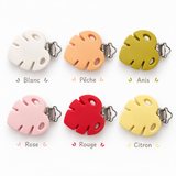 Pinces d’attache-tétine en silicone et métal en six coloris : blanc, pêche, anis, rose, rouge et citron, présentées sur fond blanc