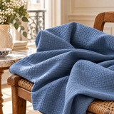 Double-gaze 100% coton bleu orage drapée sur un fauteuil dans un intérieur parisien élégant